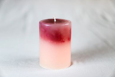Eine rosa-rote runde Kerze