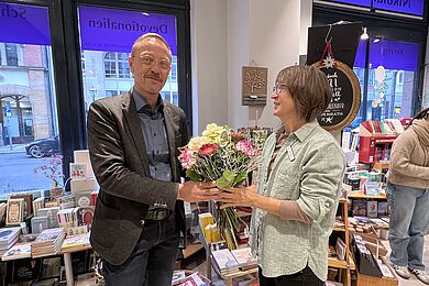 Tobias Schmidt übergibt einen Blumenstrauß