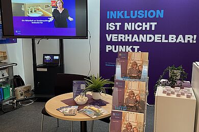 Messestand der BBW-Leipzig-Gruppe mit Bildschirm und Video