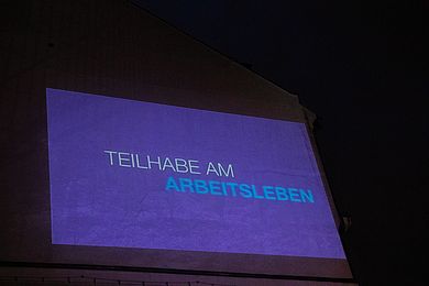 Animationsfilm mit Schlagwort "Teilhabe" auf einer Hausfassade