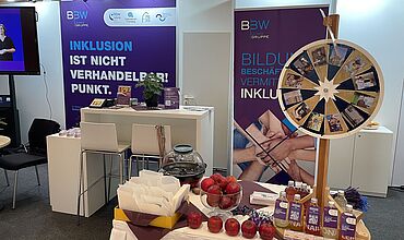 Messestand der BBW-Leipzig-Gruppe mit Roll-Ups, Glücksrad und Give-aways