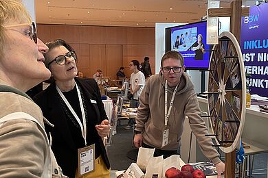 Interessierte Person am Stand des BBW dreht am Glücksrad